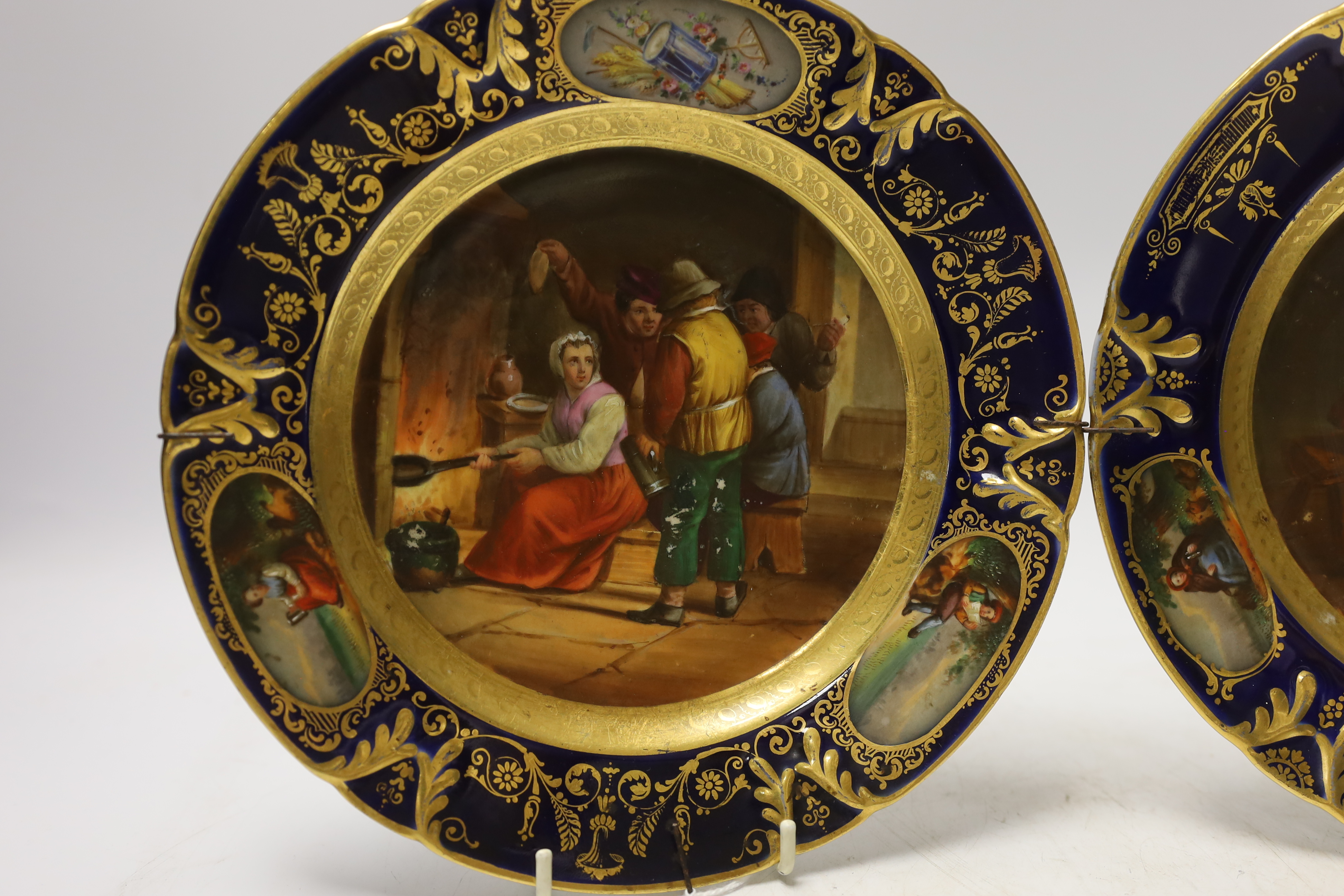 Two 19th century Vienna style plates, with painted central cartouche tavern scenes after Teniers, 22cm diameter